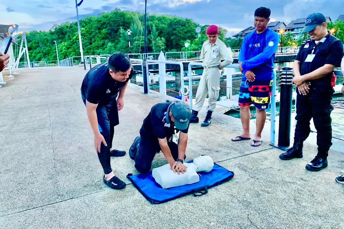 SGS team practising CPR on a training manikin at a Phuket marina dock